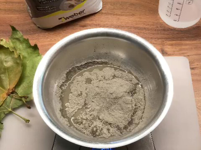 Nahaufnahme einer Metallschüssel mit Wasser und Bastelbeton