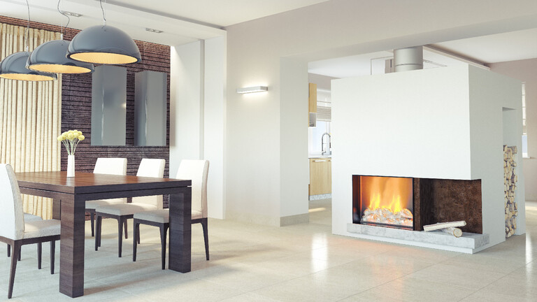 Blick in einen Essbereich mit weißen Wänden, einem Kamin auf der rechten Seite und einem Holztisch mit Stühlen auf der linken Seite
